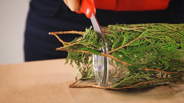 Cut the branches that stick out from the base of the vase with scissors. 