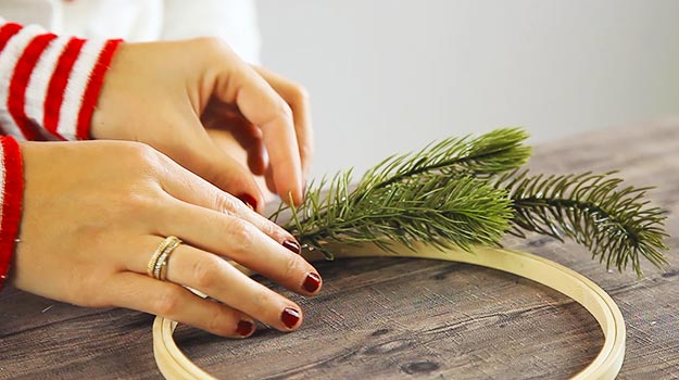Glue a small fir tree branch onto the hoop with hot glue. 