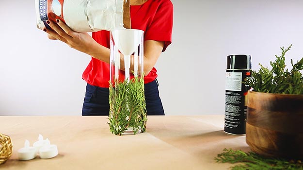 Using a small funnel, fill the vase with sugar.