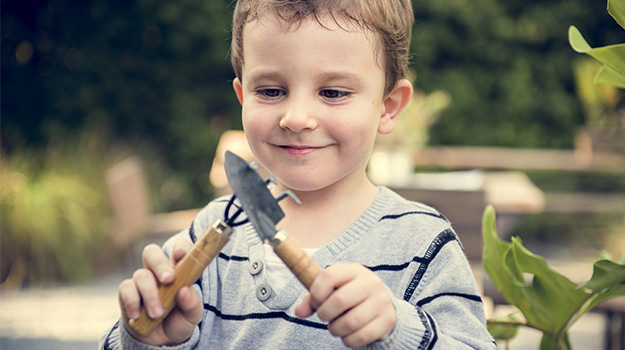 Kid playing with tiny gardening tools
