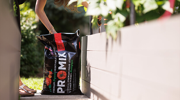 Woman preparing planters and flowerbeds in spring to grow vegetables and flowers.